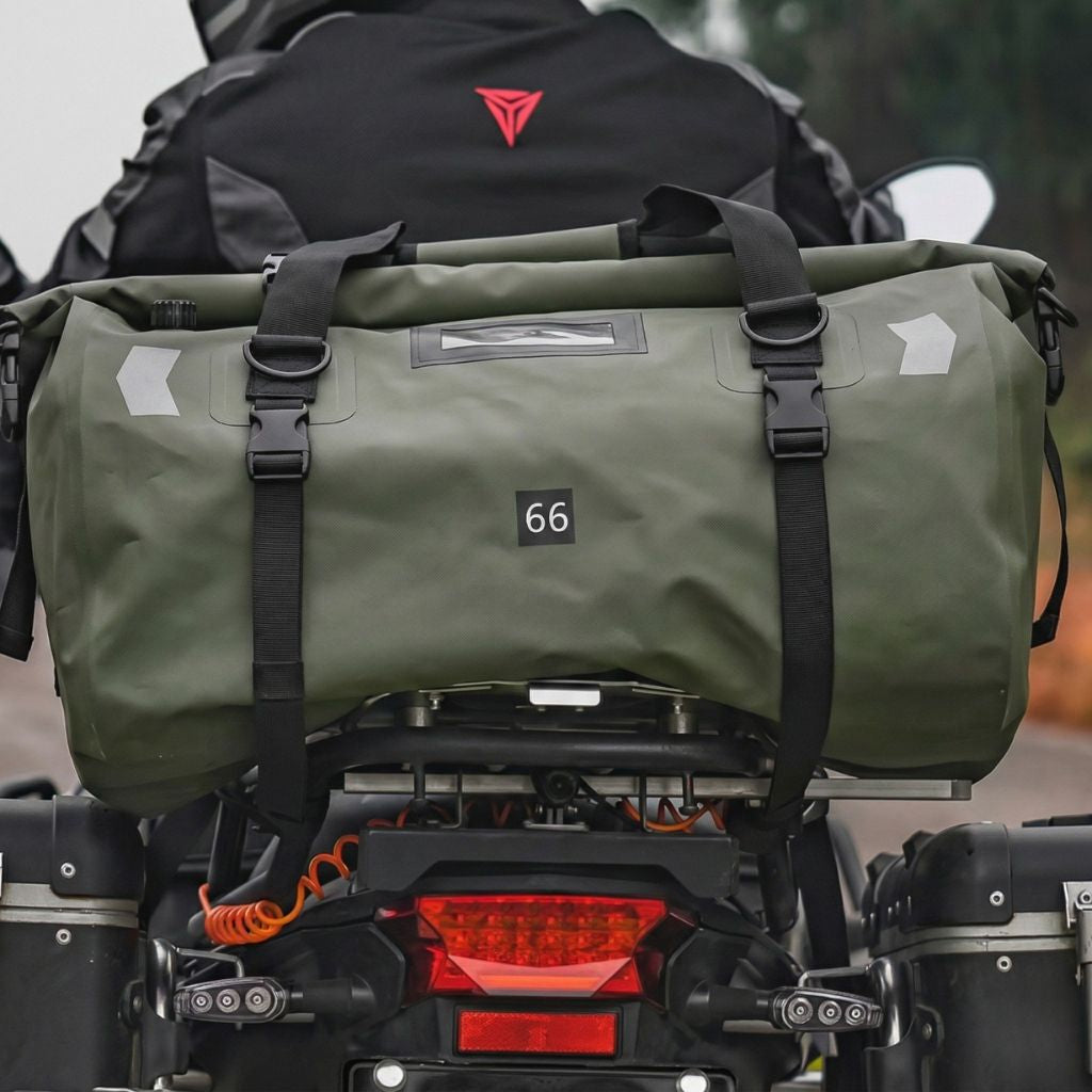 Duffle bag étanche vert kaki 66L sanglé sur porte-bagages de moto, vue de dos avec conducteur en tenue de route