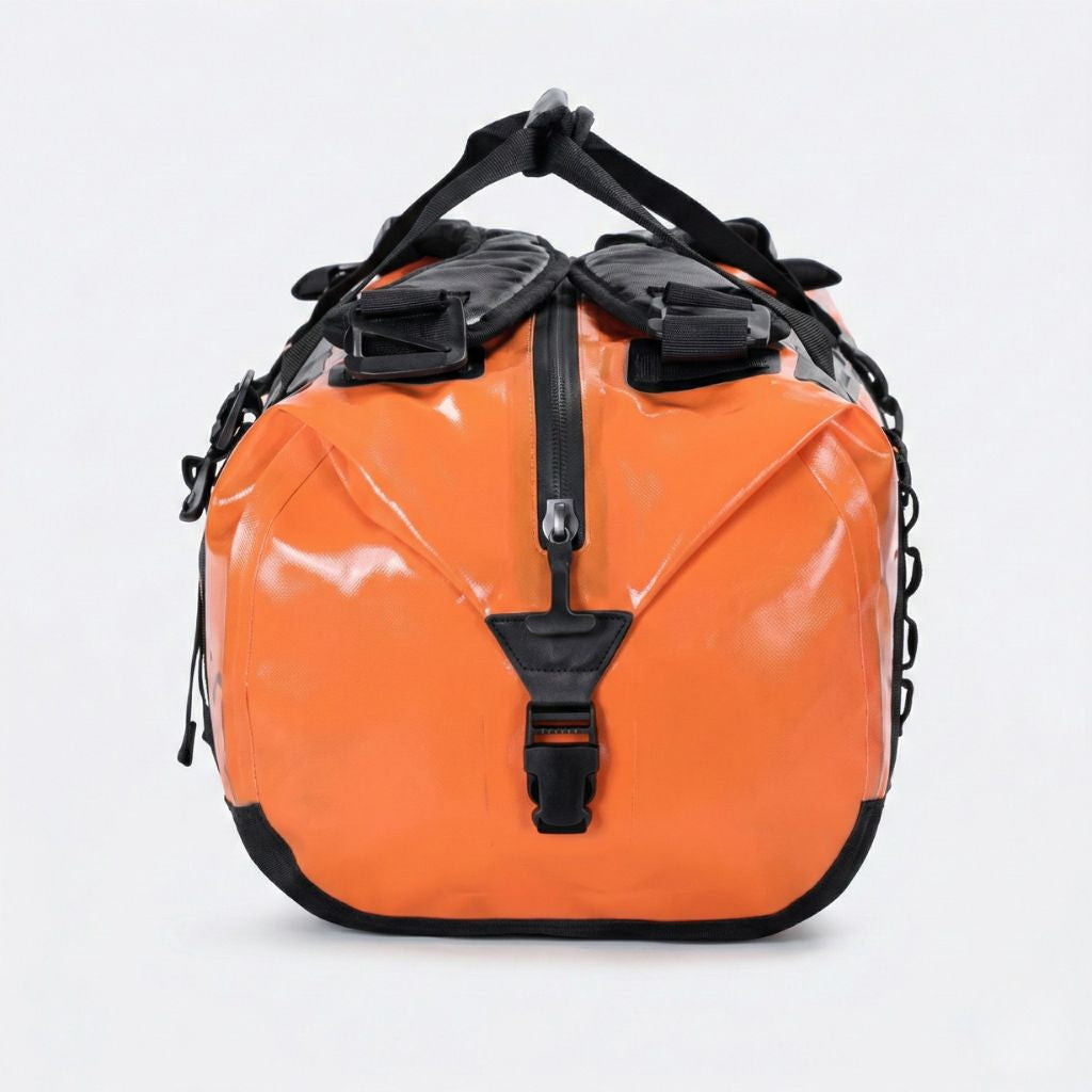 Duffle bag étanche orange 50L vu de côté, montrant la fermeture hermétique et les passants de fixation latéraux