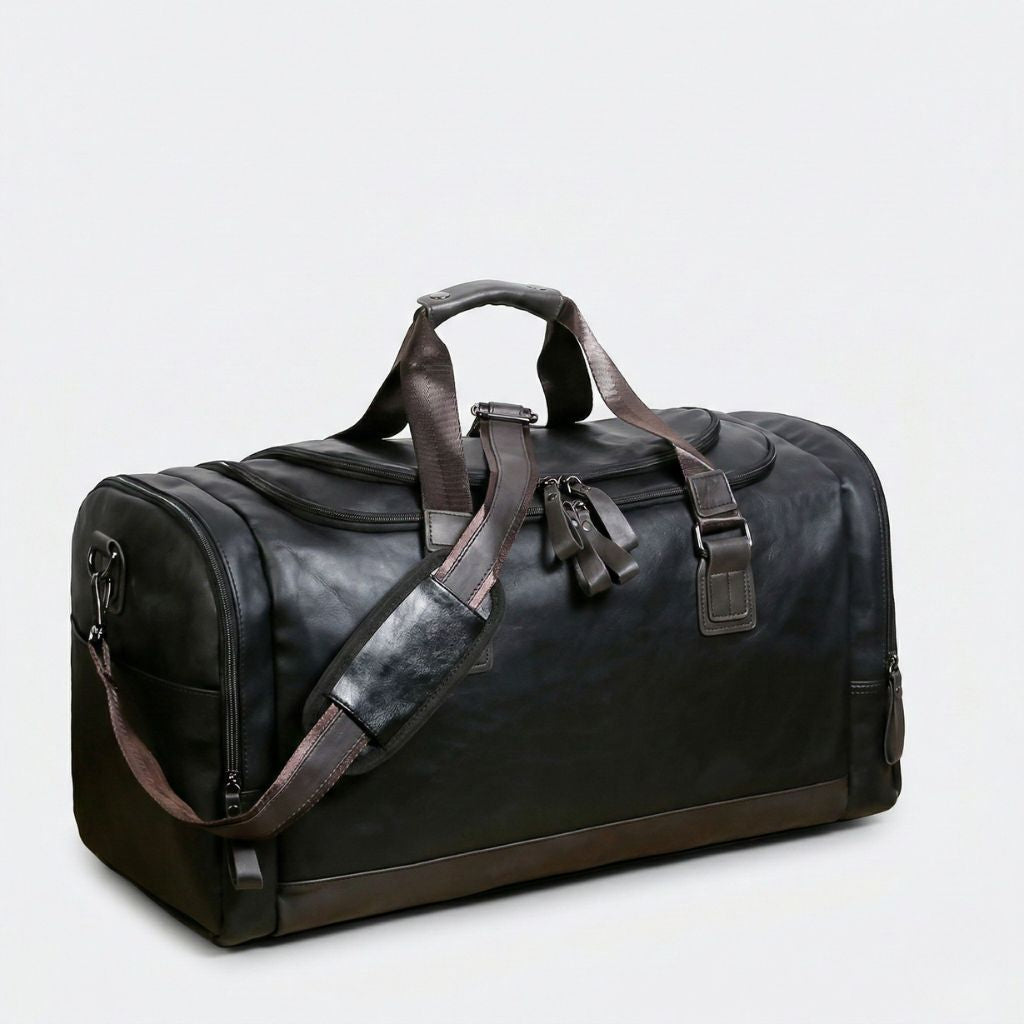 Duffle Bag cabine noir mat 42L, vue avant gauche, bandoulière cuir brun et fermetures éclairs noires
