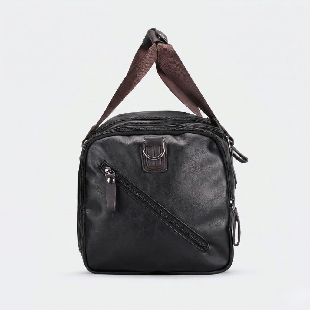 Face latérale du Duffle Bag cabine noir en simili cuir grainé, poche zippée en diagonale et anneau D métallique