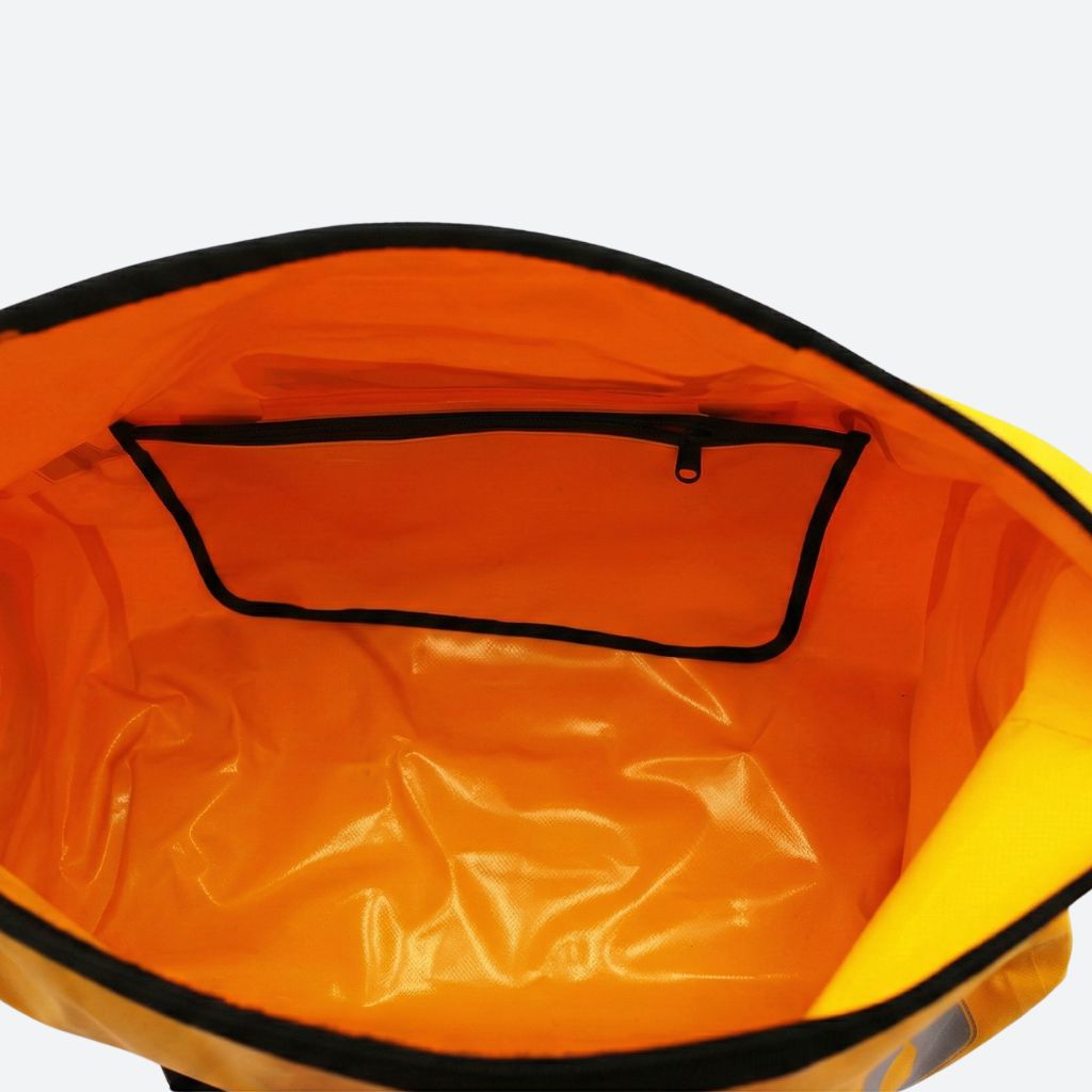 Vue plongeante dans le grand sac de voyage étanche ouvert, vaste doublure orange et poche intérieure zippée