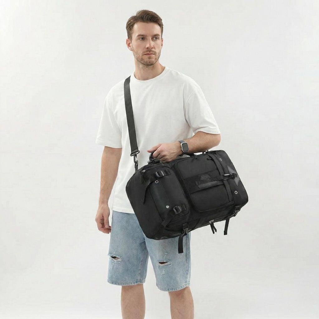 Homme portant en bandoulière un grand sac à dos de voyage noir multipoches avec sangle de poitrine Image