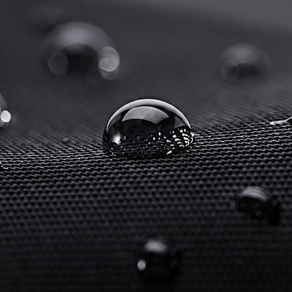 Gros plan sur la matière noire imperméable d'un sac à dos de voyage, illustrant la résistance à l'eau Image