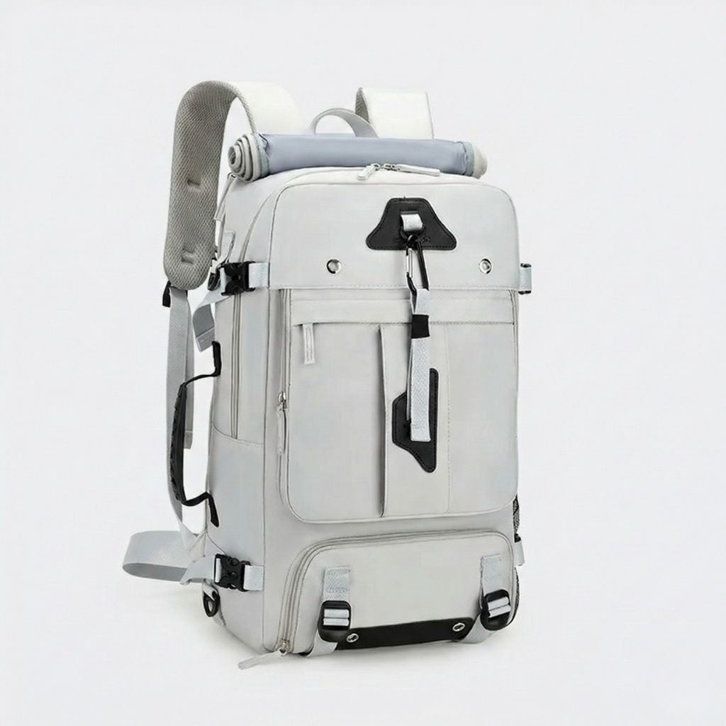 Sac à dos de voyage blanc avec bretelles grises et attaches noires, tapis de yoga roulé fixé en haut du sac