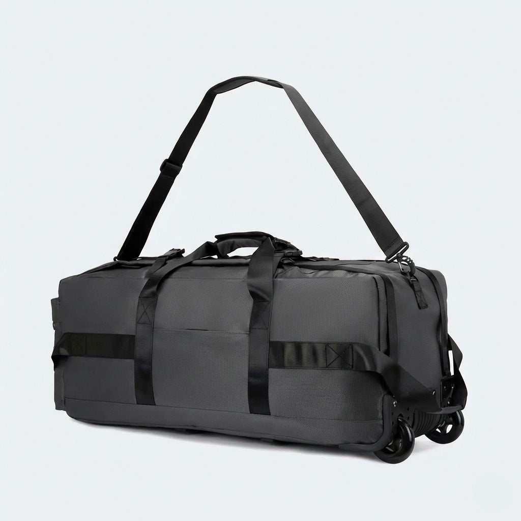 Sac de voyage gris anthracite en mode trolley avec bandoulière longue déployée et roulettes doubles