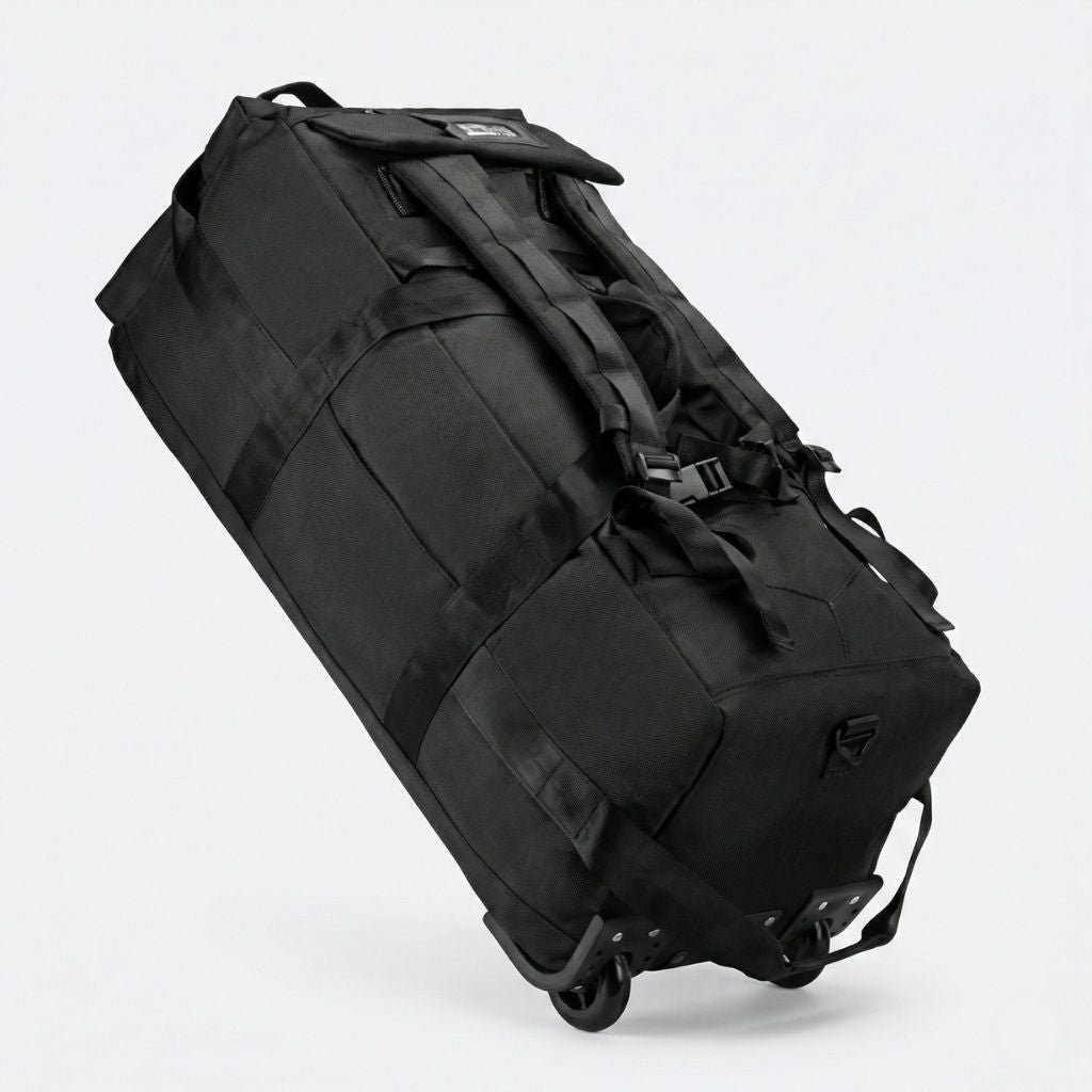 Sac de voyage noir en mode trolley incliné vu en plongée, roulettes doubles noires apparentes