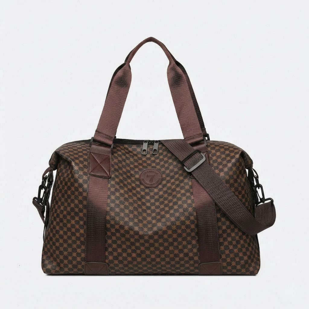 Face du sac cabine damier marron caramel avec badge rond central et double zip, bandoulière