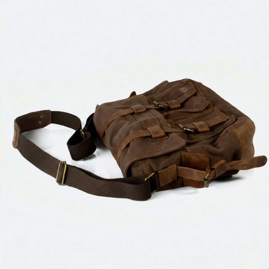 Vue plongeante du sac besace XL marron chocolat waxé posé à plat, bandoulière et D-rings laiton visibles