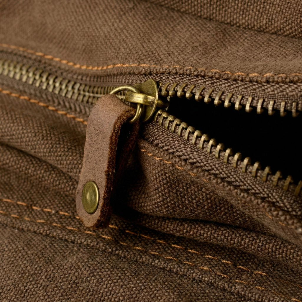 Gros plan de la fermeture éclair à dents laiton et tirette cuir brut du sac besace XL toile waxée