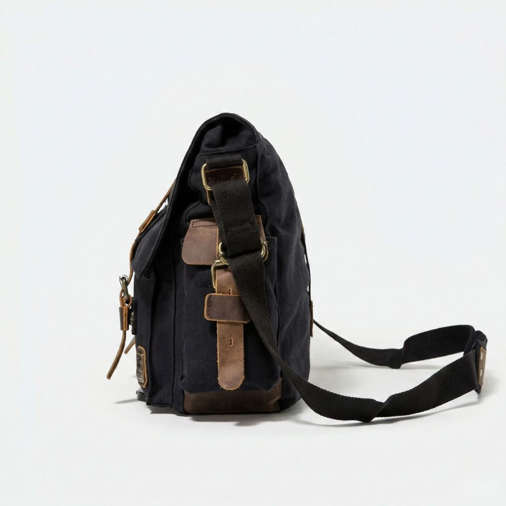 Vue de profil du sac besace XL noir avec renforts cuir en base et bandoulière réglable noire
