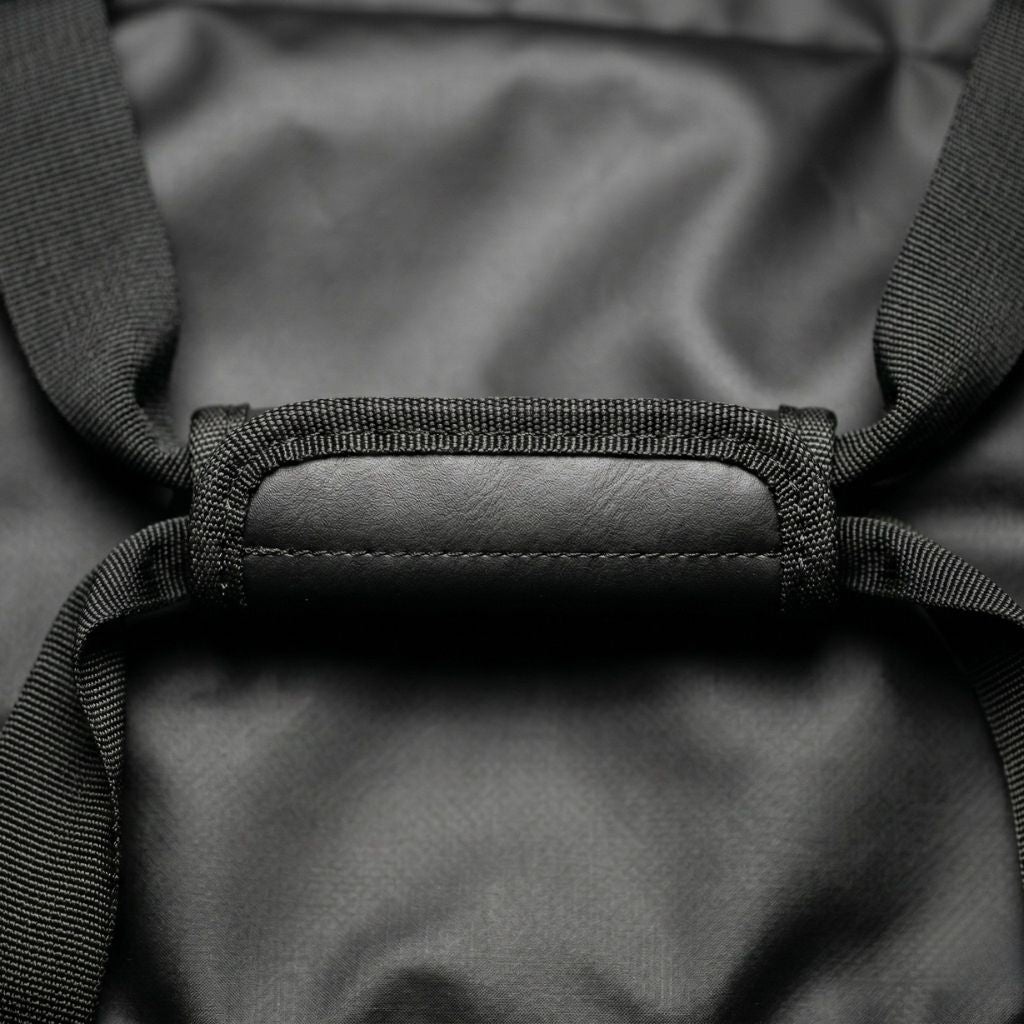 Gros plan de la poignée de portage rembourrée noire du sac étanche moto avec doublure intérieure visible