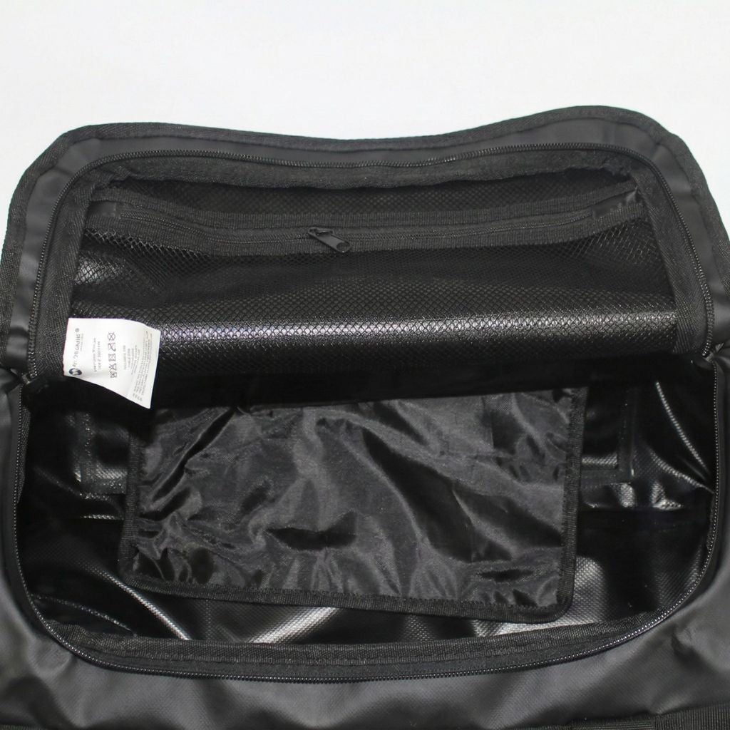 Vue intérieure du sac imperméable noir ouvert, compartiment principal avec poche mesh et poche zippée intégrées