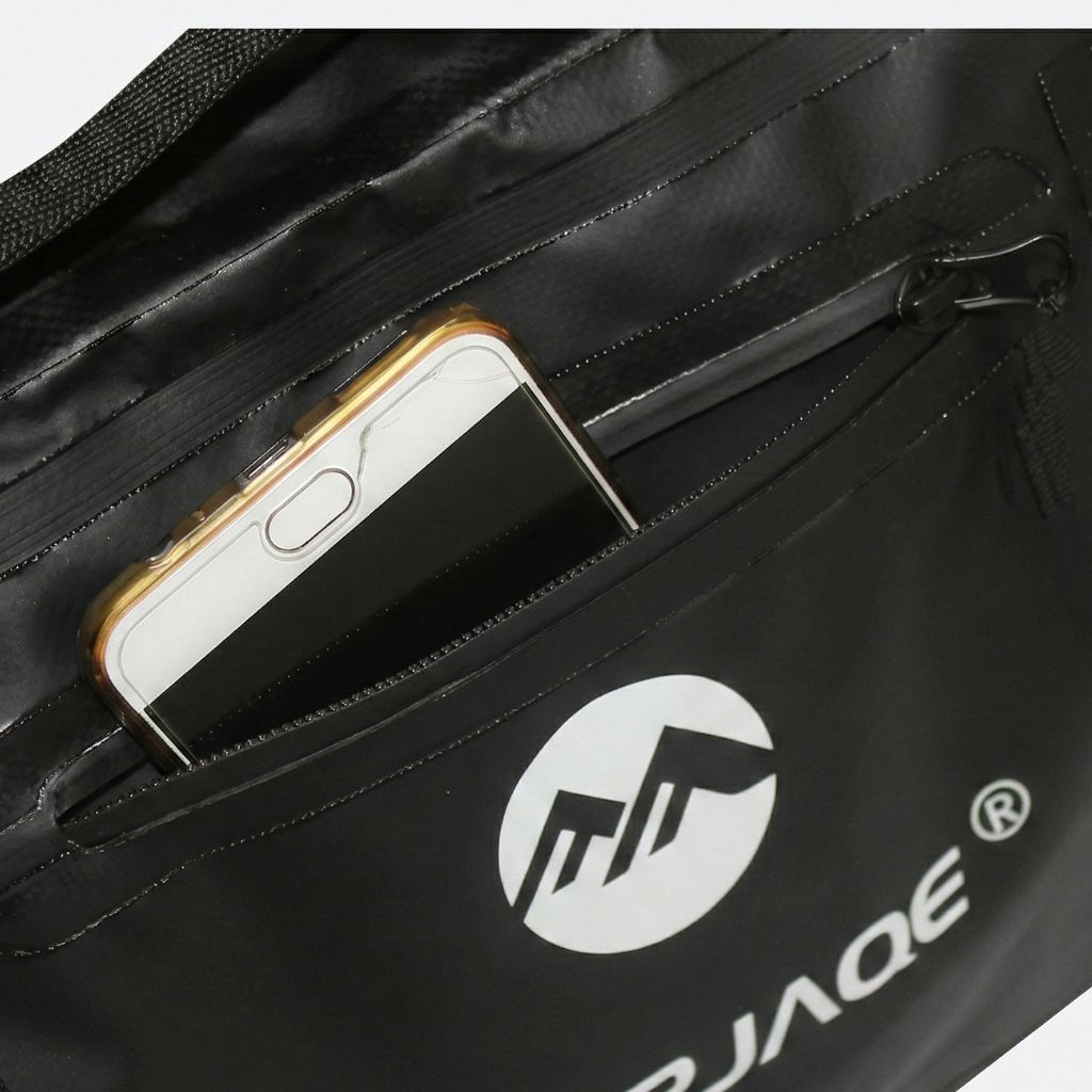Gros plan de la poche frontale étanche du sac de voyage avec un smartphone inséré, capacité de rangement pratique