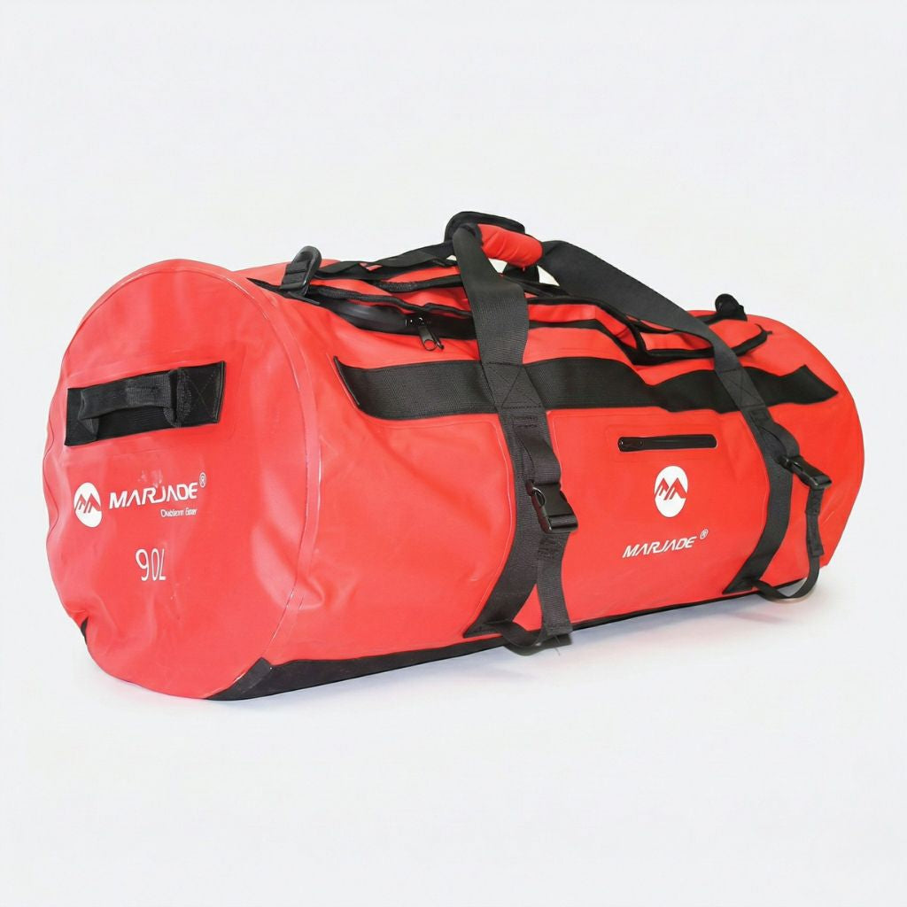 Sac imperméable rouge 90L en format duffle cylindrique, idéal pour la moto, vu de 3/4 avec sangles noires