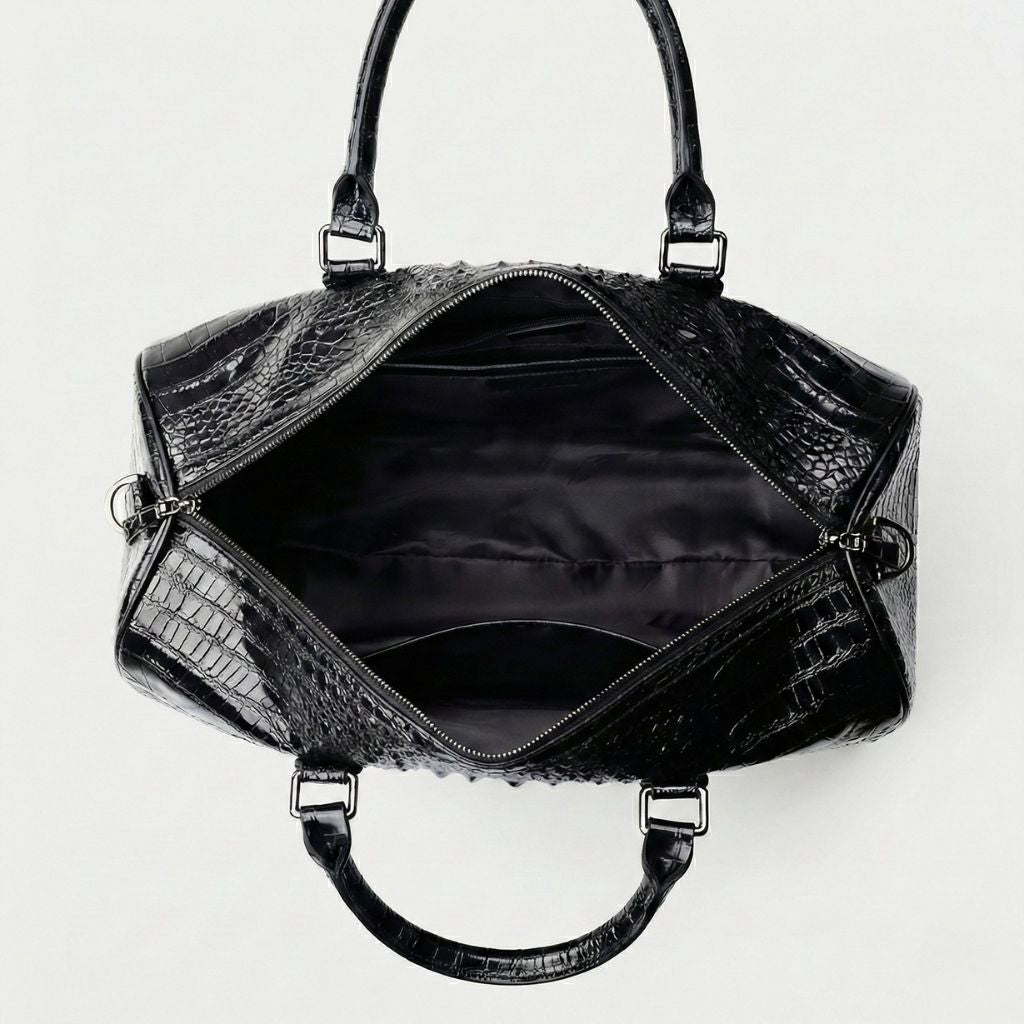 Intérieur ouvert du sac de voyage croco noir : doublure satin noire, grande cavité et fermeture zip