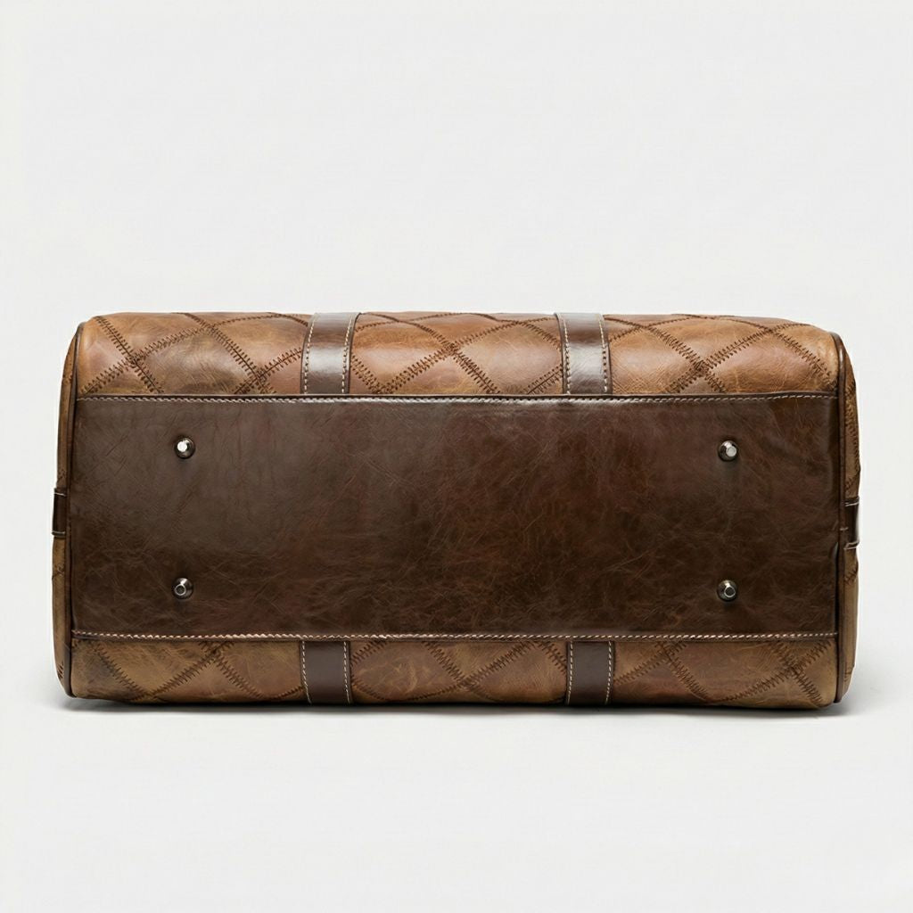 Fond du sac de voyage cuir patchwork cognac retourné, semelle lisse brun foncé et quatre rivets protecteurs