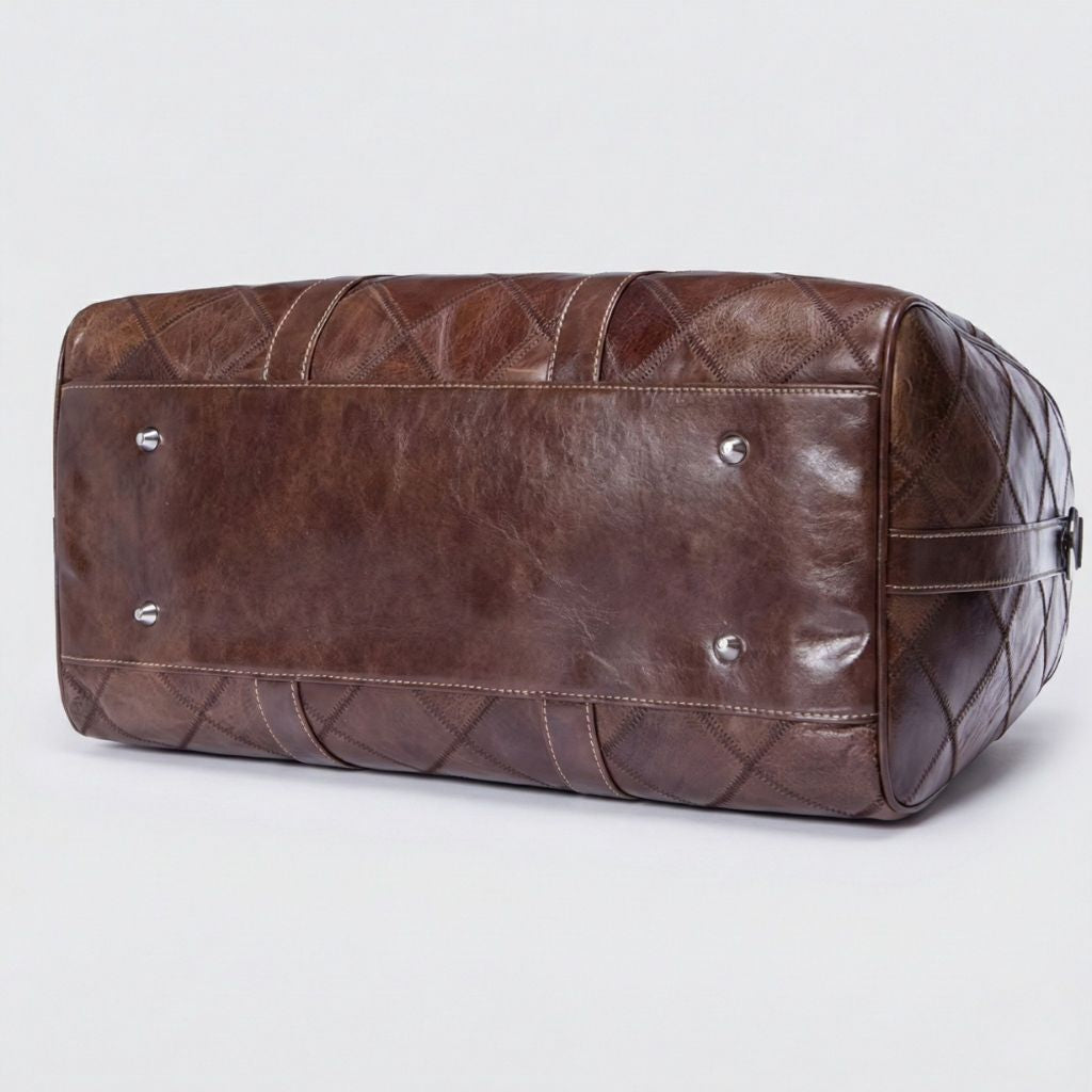 Dessous du sac de voyage cuir patchwork brun chocolat avec quatre pieds protecteurs argentés et coutures