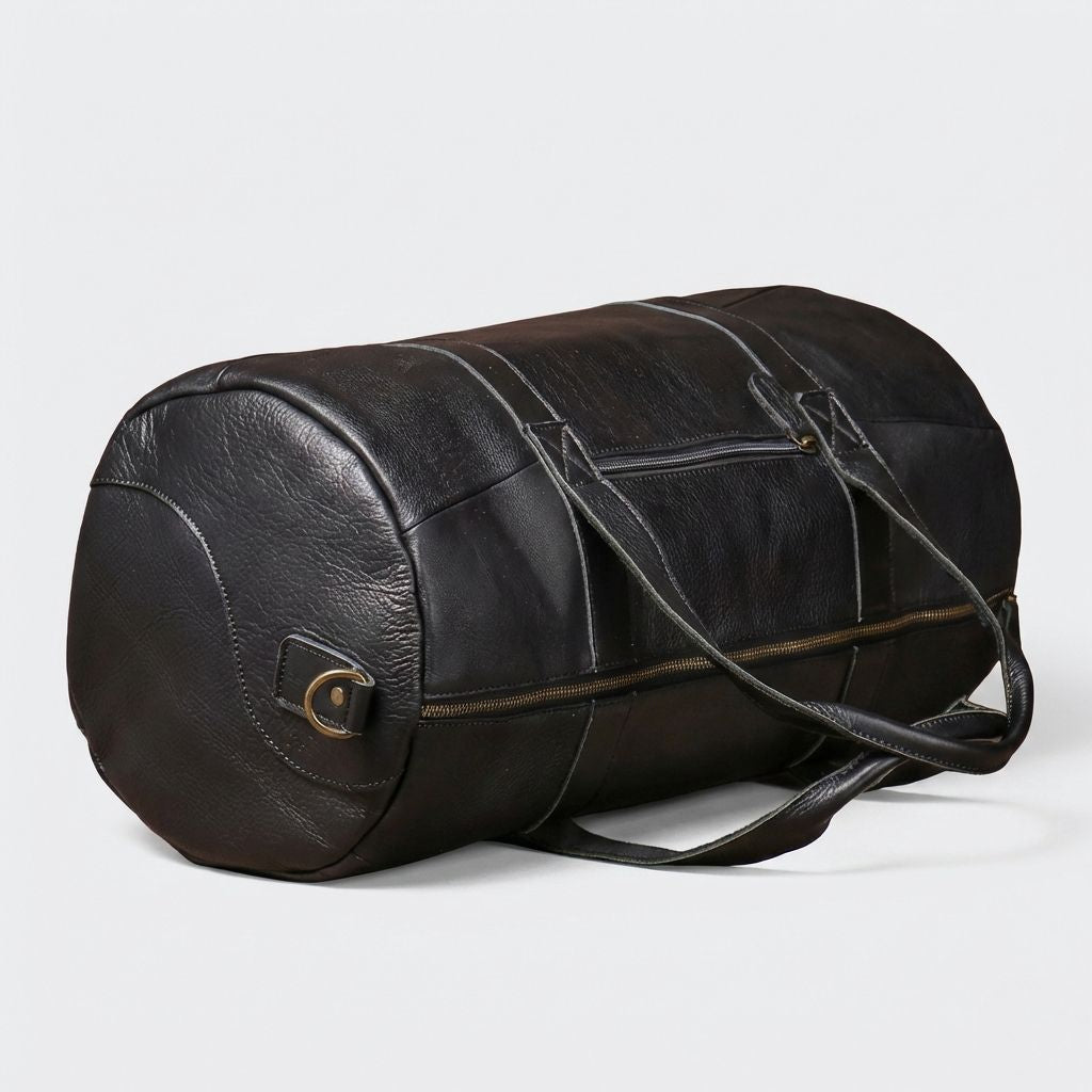 Sac de voyage cuir noir mat cylindrique couché sur le côté, anneau en D, fermetures zip et assemblage panneaux