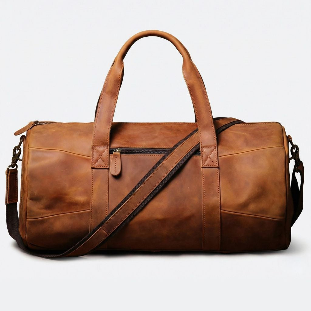 Vue de face du sac de voyage cuir cognac vintage, coutures en croix et poche zippée avant en détail