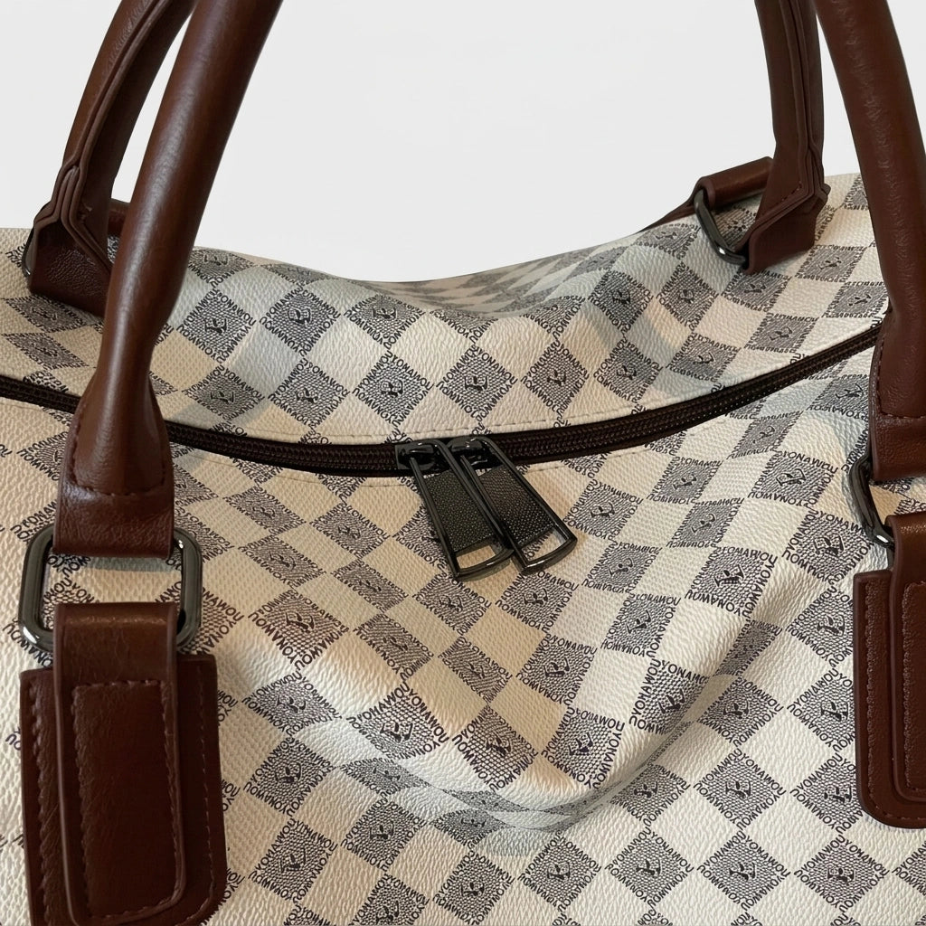 Détail de la fermeture éclair double curseur sur le dessus du sac week-end motif damier beige