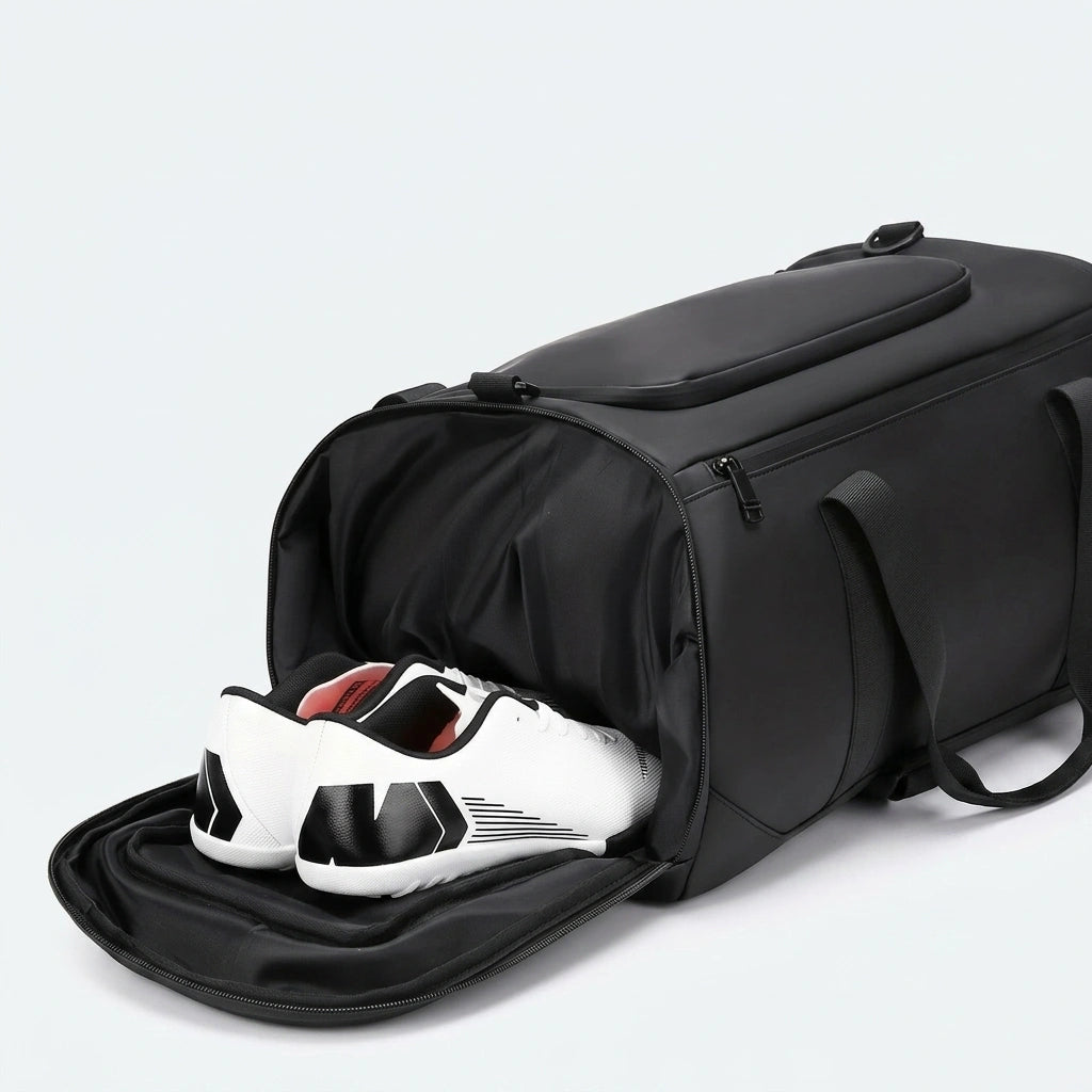 Compartiment chaussures ouvert d'un sac de voyage noir 25L avec paire de sneakers blancs et noirs