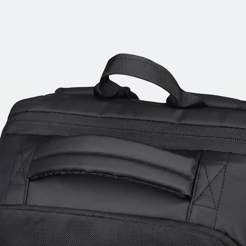 Détail de la poignée supérieure renforcée du sac à dos business noir avec coutures croisées résistantes