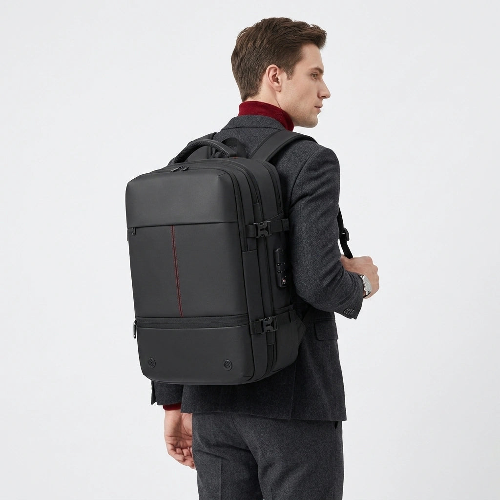 Homme en costume sombre portant le sac à dos business noir sur le dos de profil en style voyage affaires