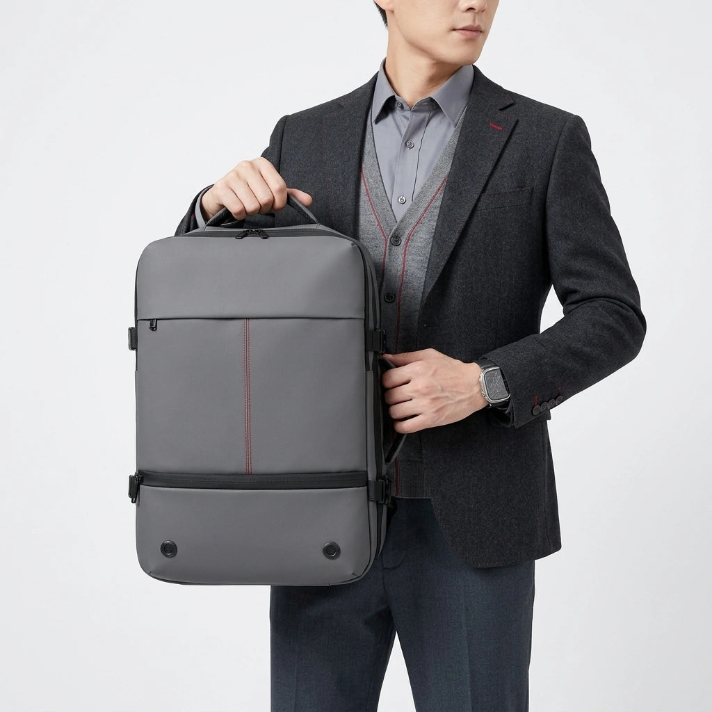 Homme en costume tenant le sac à dos business gris par la poignée supérieure avec une posture élégante