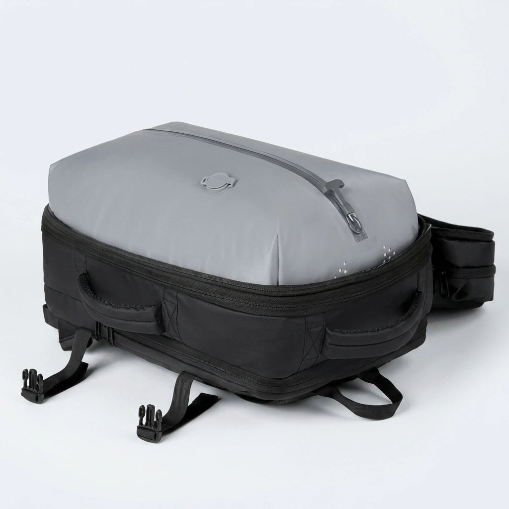 Vue du dessous du sac à dos de voyage montrant le compartiment étanche gris avec oeillets de ventilation