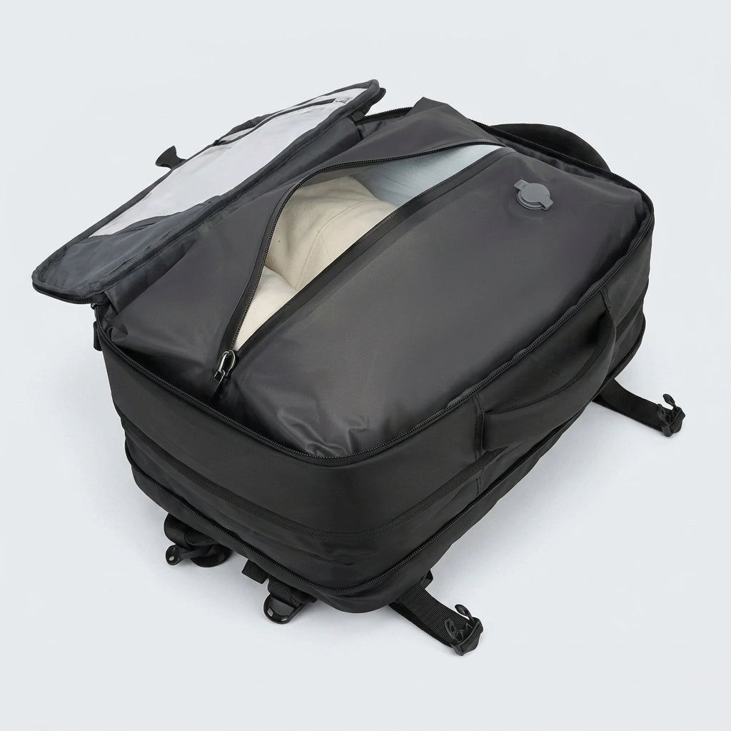 Sac à dos de voyage noir ouvert montrant le sac de compression avec valve et vêtements à l'intérieur