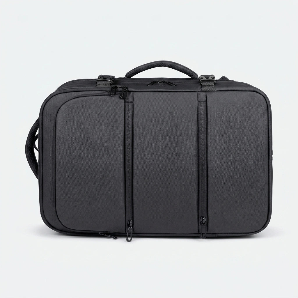 Sac à dos cabine noir posé à plat en mode valise montrant les trois compartiments frontaux zippés