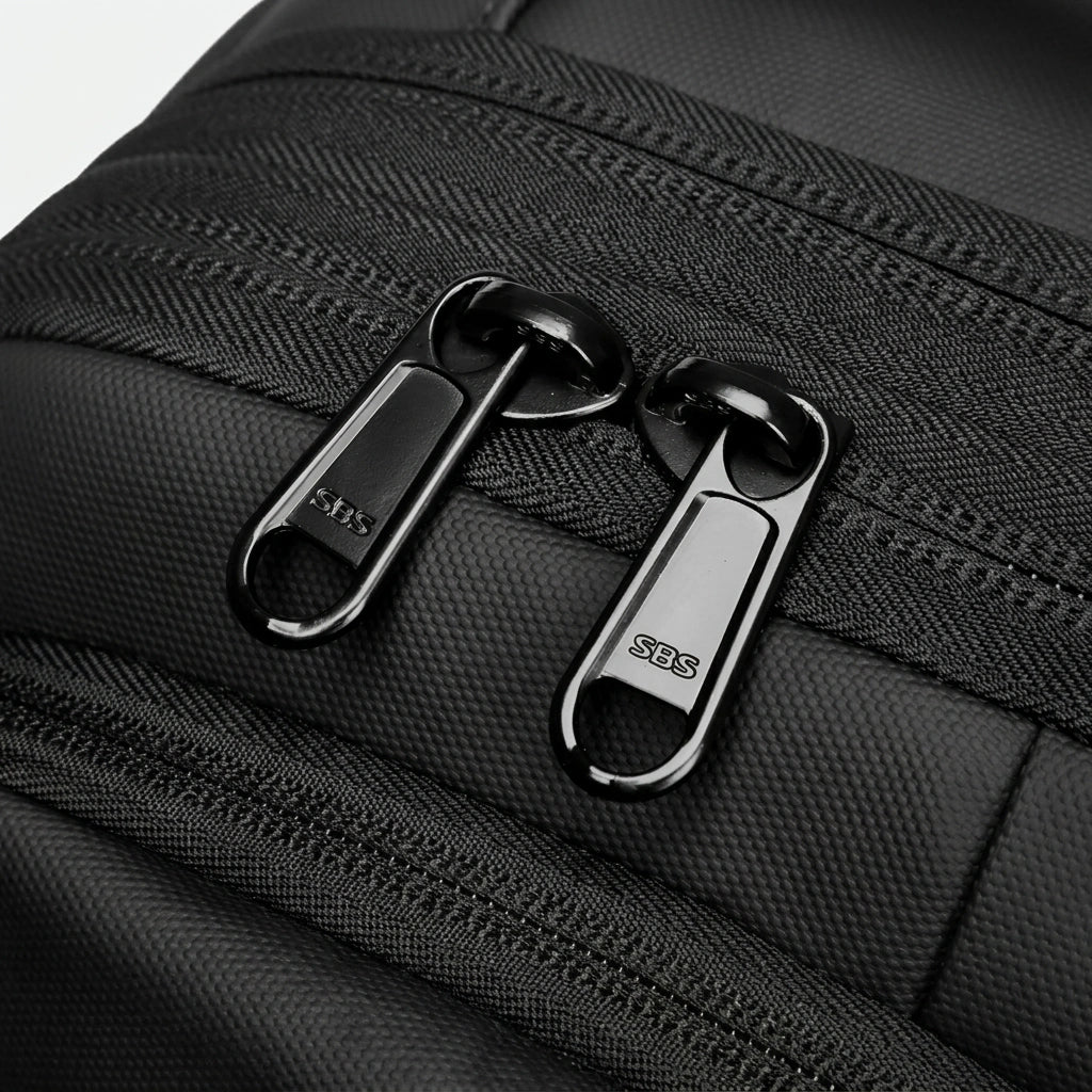 Détail des curseurs de fermeture éclair métalliques SBS sur le sac à dos cabine noir, finition chromée