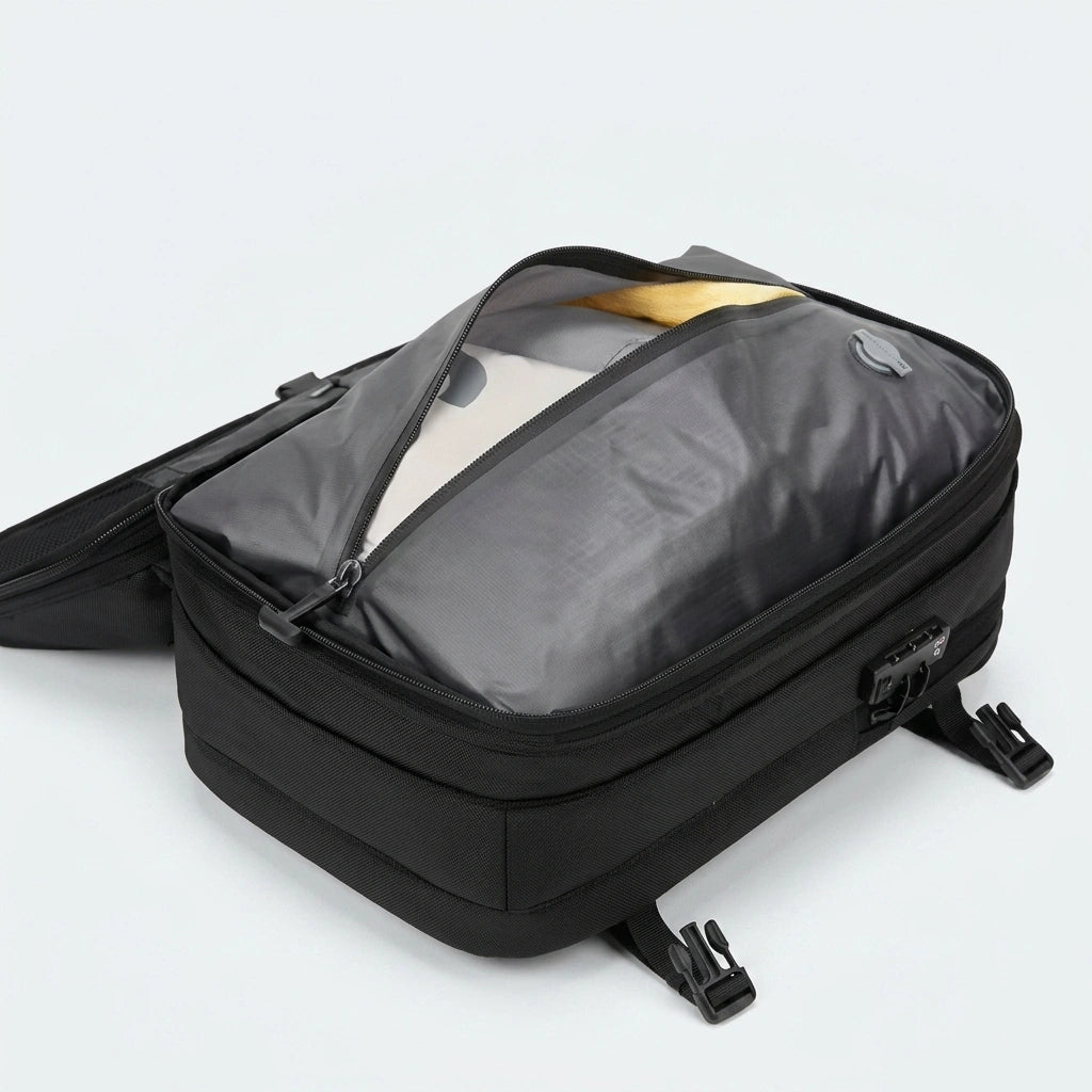 Sac à dos cabine noir entrouvert montrant le sac de compression avec vêtements et cadenas TSA visible