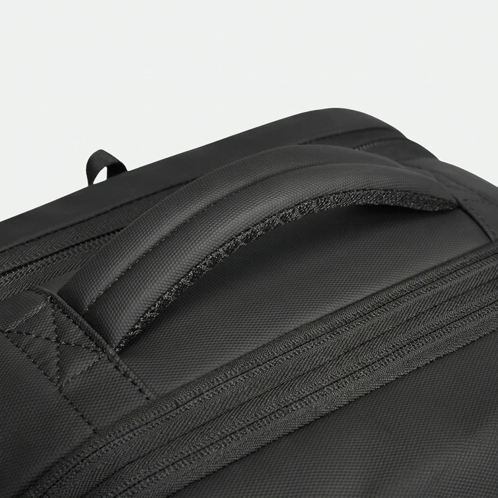 Gros plan de la poignée supérieure rembourrée du sac à dos cabine noir en toile Oxford imperméable texturée