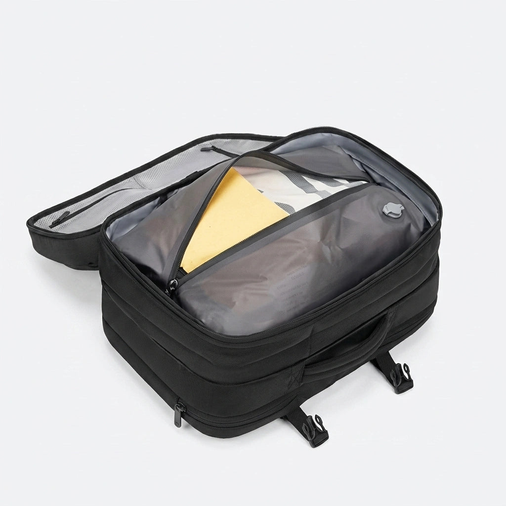 Sac à dos cabine noir ouvert montrant la housse de compression sous vide grise avec vêtements à compresser