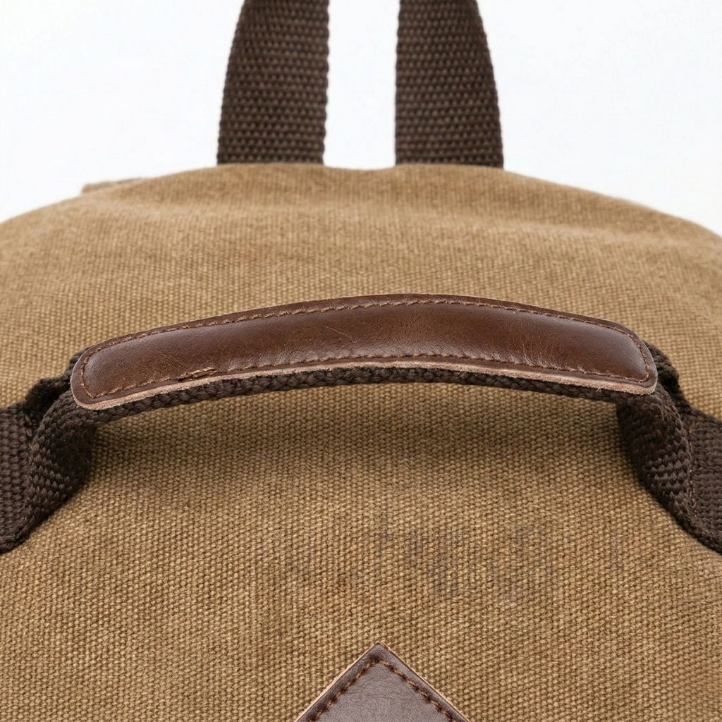 Détail de la poignée en cuir véritable marron cousue sur le dessus du sac à dos de voyage convertible
