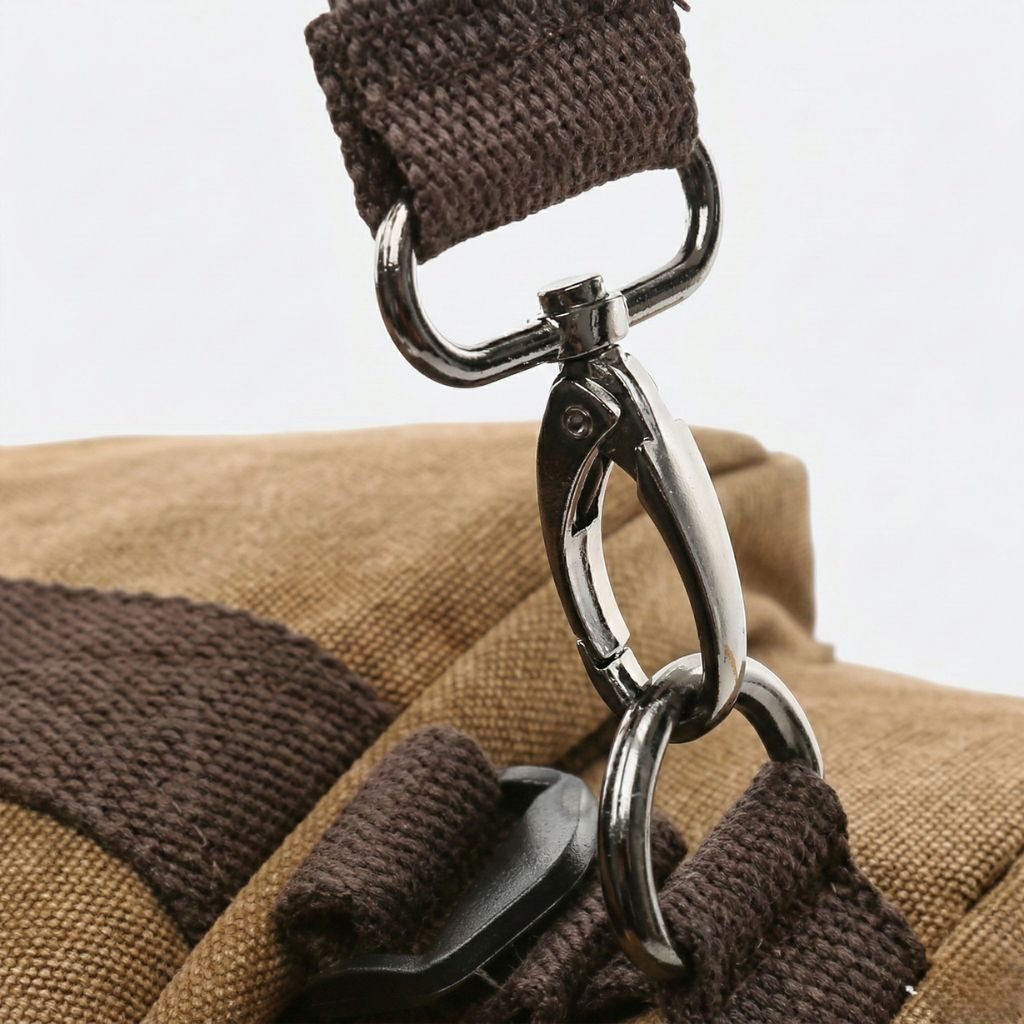 Gros plan sur la boucle métallique et la sangle en toile lavée brune d'un sac à dos duffle convertible Image