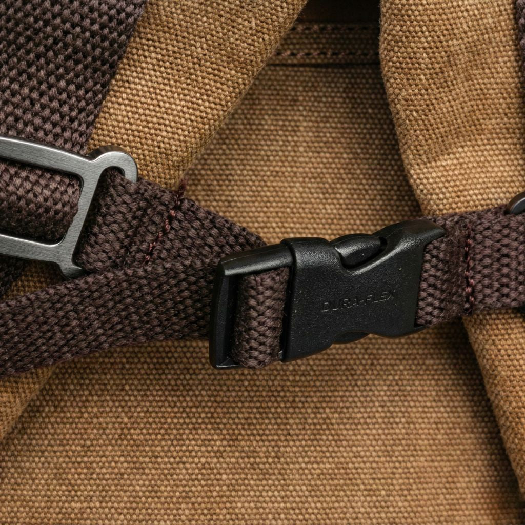 Gros plan d'une boucle Duraflex noire fixée sur toile lavée kaki, garantissant une fermeture de sac sécurisée
