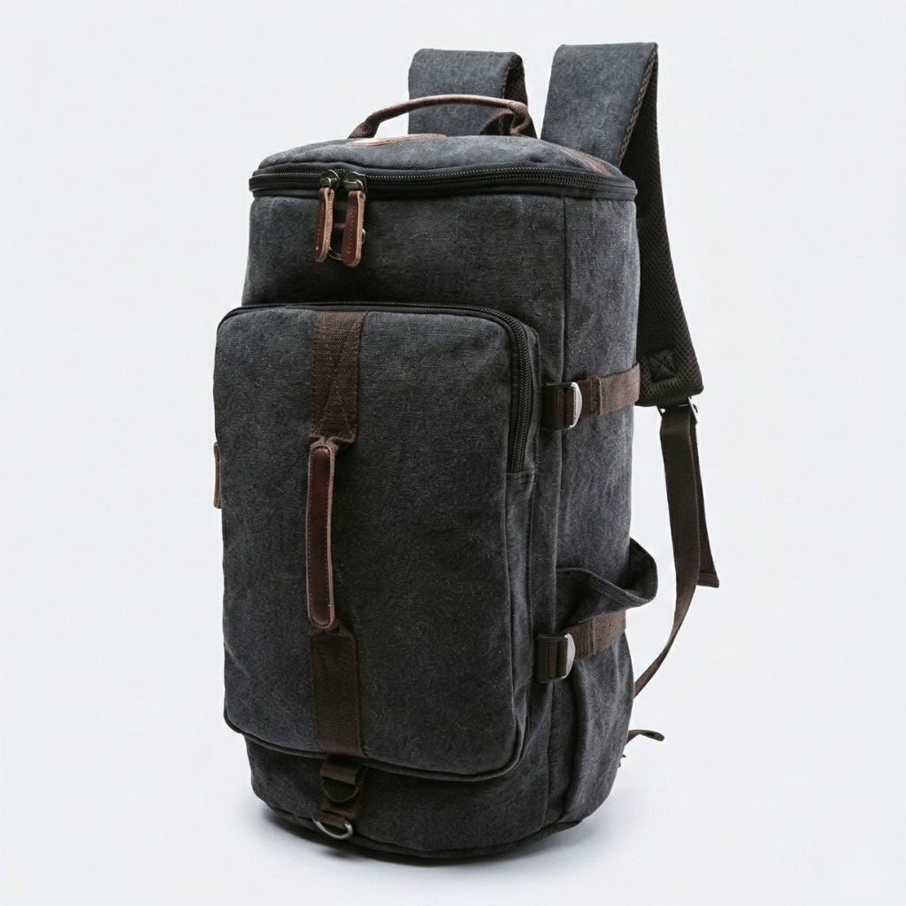 Vue 3/4 du sac à dos de voyage noir anthracite en toile lavée convertible, poche frontale et bretelles visibles