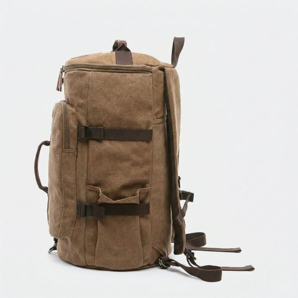 Vue latérale du sac à dos duffle brun camel en toile lavée, bretelles réglables et poignée de portage visible