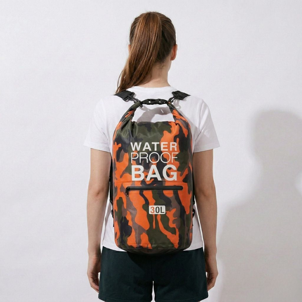 Femme portant un sac de voyage étanche camouflage 30L, vue de profil, illustrant la capacité de portage dorsal