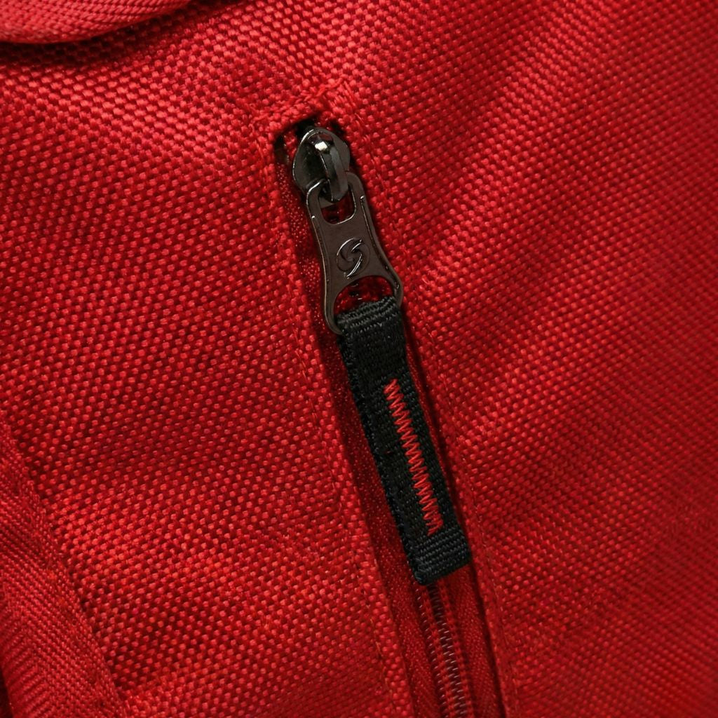 Gros plan sur la fermeture éclair noire du sac à dos rouge, détail du curseur de zip de qualité