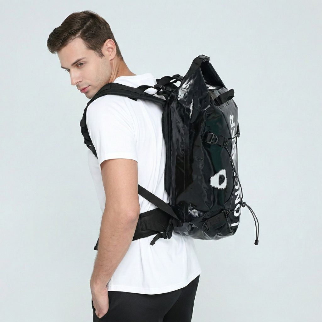 Homme de profil portant le sac étanche noir roll-top 35L, idéal pour les activités sportives outdoor