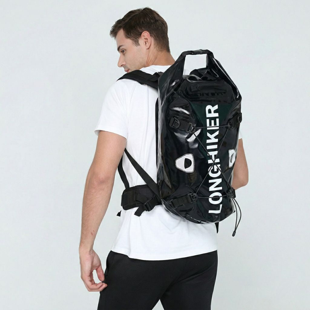Homme de trois quarts dos portant le sac étanche noir roll-top lors d'une activité sportive en extérieur Image