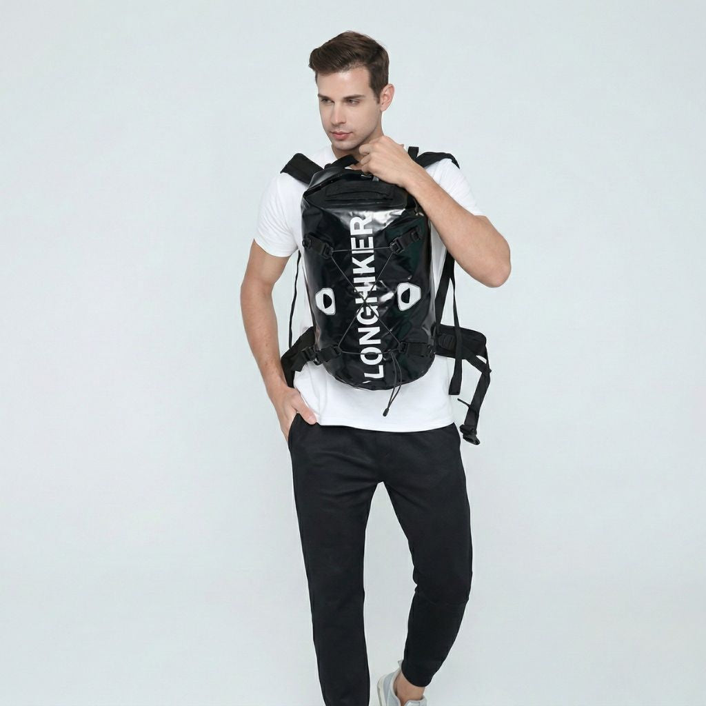 Homme de trois quarts face portant et ajustant le sac étanche noir roll-top sur son épaule