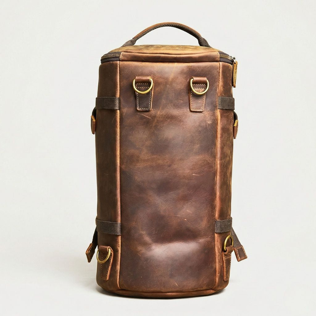 Face arrière du sac cylindrique cuir brun vertical, panneaux lisses et attaches canvas pour bretelles