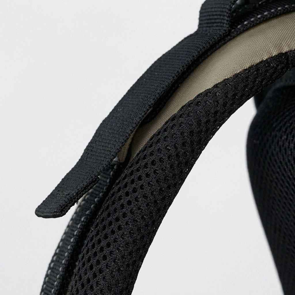 Gros plan sur la bretelle rembourrée mesh noir d'un sac à dos de randonnée, avec sangle de réglage en nylon