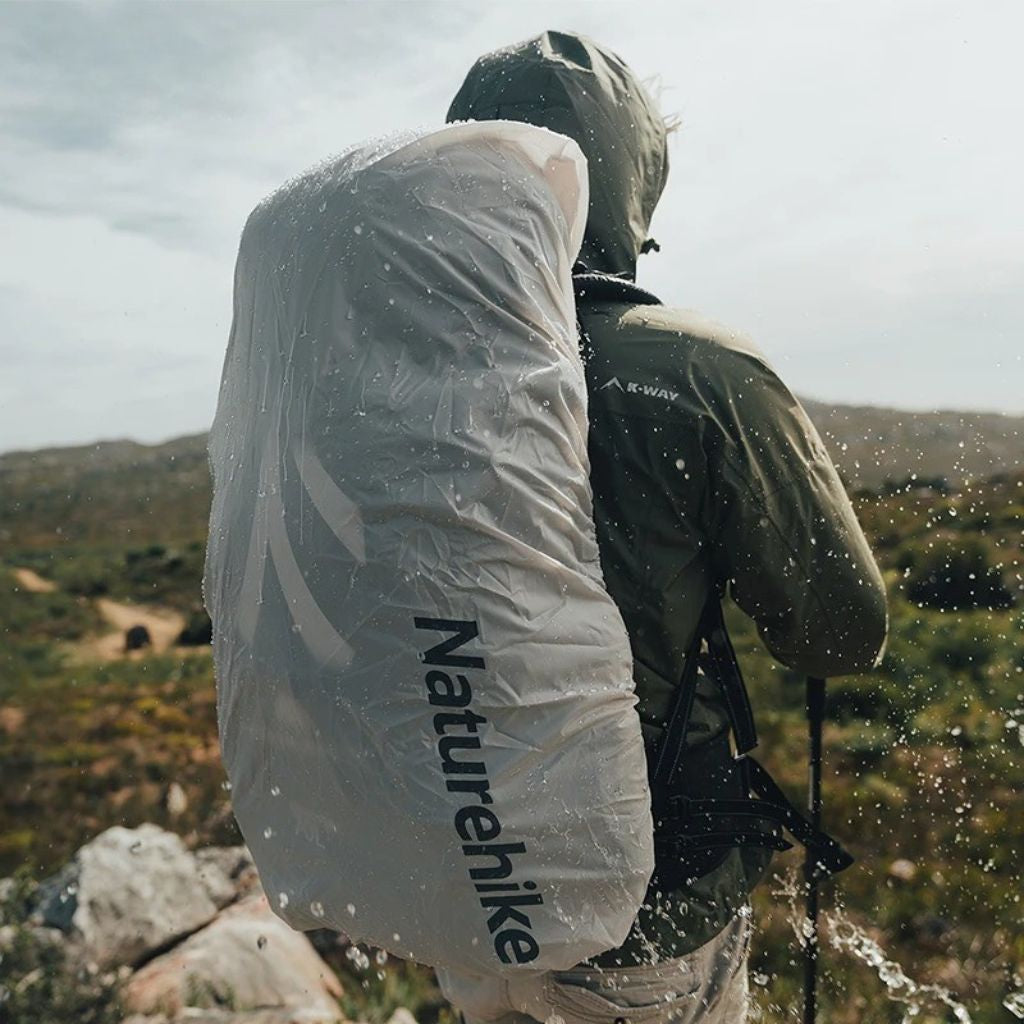 Randonneur de dos sous la pluie portant le sac à dos trekking 70L avec housse de pluie blanche translucide Image