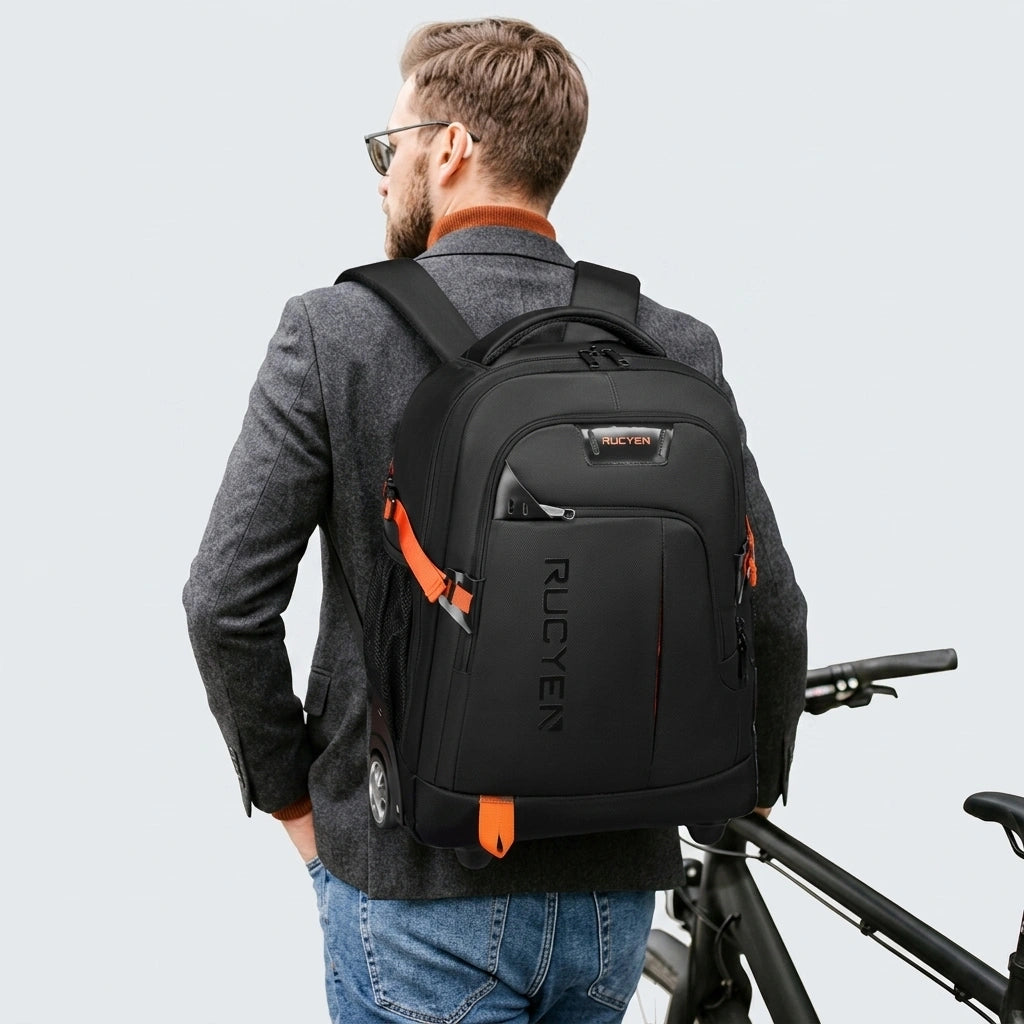 Homme en veste grise portant un sac à dos trolley noir et orange 33L, vue de dos avec vélo