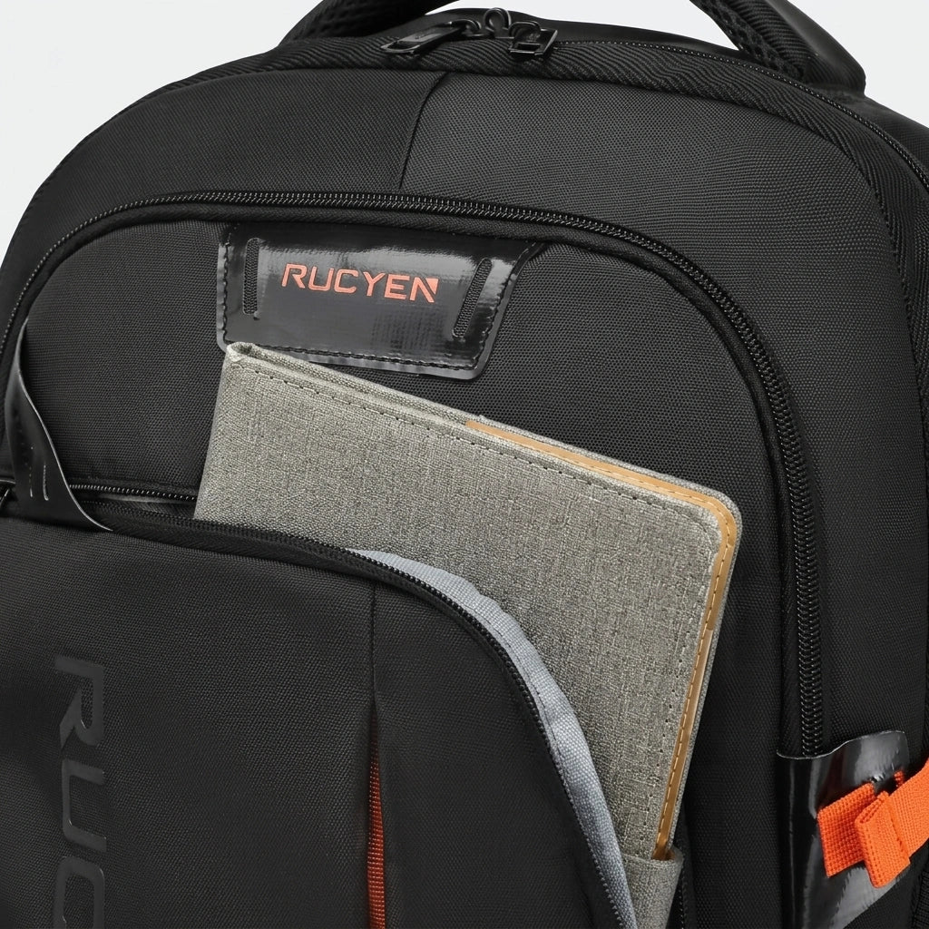 Gros plan poche frontale du sac de voyage trolley noir 33L, carnet gris inséré et poignée souple